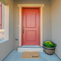 A red door with peep hole and deadlock bolt.