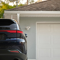 Black car parked in driveway of home.